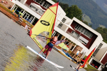 Windsurfen beim Sporthotel ROYAL X – Urlaub am Millstätter See – Naturhäuschen Leitner – Urlaub in Kärnten am See